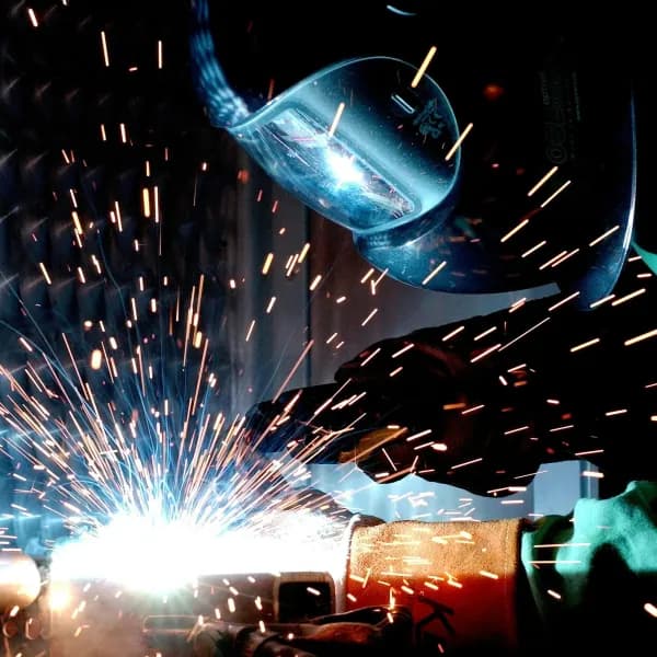 A welder working with metal, sparks flying